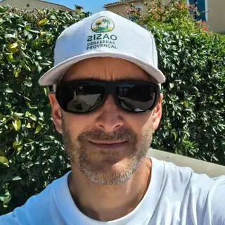 Rémi, le jardinier d'Oasis, devant une haie